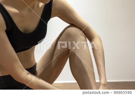 身材苗條的女人穿著黑色運動服坐下 身材苗條的女人穿著黑色運動服坐下 98903590