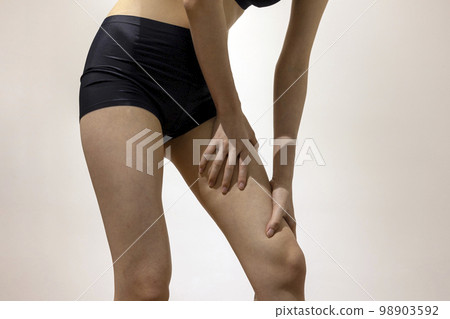 穿著黑色運動服的女人用手遮住大腿和腿 98903592