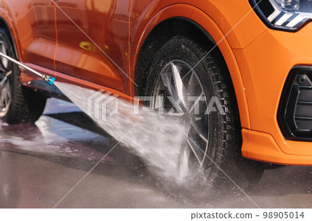 Close-up of washing wheels using a jet sprayer Close-up of washing wheels using a jet sprayer 98905014