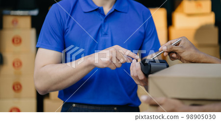 Asian delivery man, Hand using smart phone to scan QR code on tag, concept of parcel delivery, Qr code payment concept. Asian delivery man, Hand using smart phone to scan QR code on tag, concept of parcel delivery, Qr code payment concept. 98905030