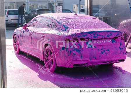 Luxury sport blue car on self servise car washing. Pink foam on auto. Back view Luxury sport blue car on self servise car washing. Pink foam on auto. Back view 98905046