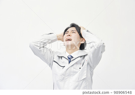 一個穿著工作服的男人抱著頭 白色背景 98906548