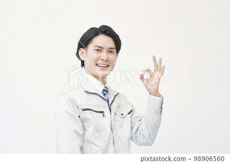 Man in work clothes giving OK sign white background 98906560