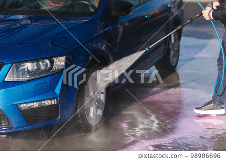 Worker cleaning car using high pressure water. Self servise car washing. Clean auto Worker cleaning car using high pressure water. Self servise car washing. Clean auto 98906696