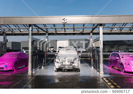 Different cars on self car wash. Layer of foam on the car. Pink and white soap. Big auto washing Different cars on self car wash. Layer of foam on the car. Pink and white soap. Big auto washing 98906717