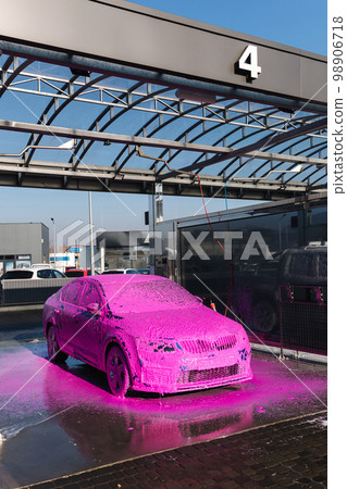 Luxury sport blue car on self servise car washing. Pink foam on auto. Close up Luxury sport blue car on self servise car washing. Pink foam on auto. Close up 98906718