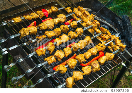 Assorted delicious grilled meat with vegetables over the coals on a barbecue Assorted delicious grilled meat with vegetables over the coals on a barbecue 98907296