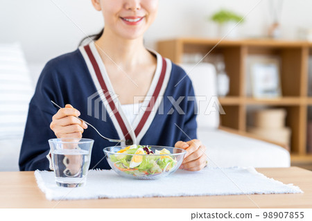 A young woman eating a salad A young woman eating a salad 98907855
