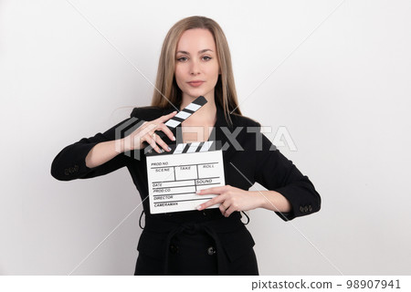 Sensuality beautiful woman with long hair, dressed in black suit in studio, holding clapperboard 98907941