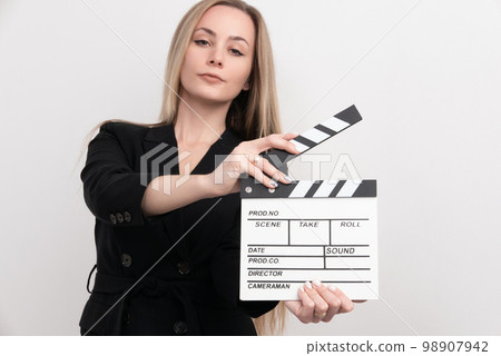Sensuality beautiful woman with long hair, dressed in black suit in studio, holding clapperboard 98907942