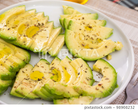 ripe avocado pulp cut into pieces sprinkled with lemon juice on a plate 98908232