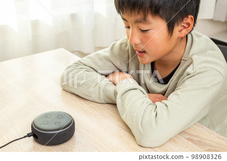 boy talking to smart speaker 98908326
