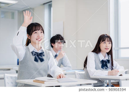 High school girl raising her hand in class High school girl raising her hand in class 98908394