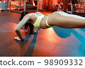 Young athletic woman doing push-ups in the gym. Muscular woman doing push-ups in the gym 98909332