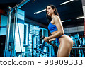 Sporty woman exercising on multistation at gym . Fitness exercising in the gym 98909333