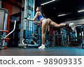 Beautiful fitness woman doing leg exercises in the gym 98909335