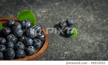 Blueberries on a textured black background, copy space. 98910093