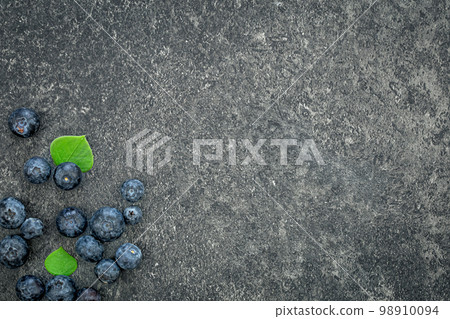 Blueberries on a textured black background, top view. 98910094