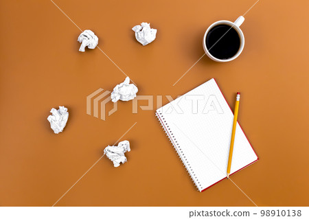 Empty notebook with cup of coffee and crumpled paper balls, flat lay. Empty notebook with cup of coffee and crumpled paper balls, flat lay. 98910138