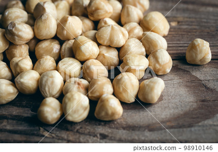 Heap of roasted hazelnuts close-up on a wooden background. 98910146