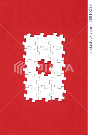 White puzzles on a red background, flat lay. 98910259