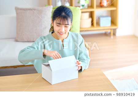 A young plainclothes woman checking her luggage at home A young plainclothes woman checking her luggage at home 98910419