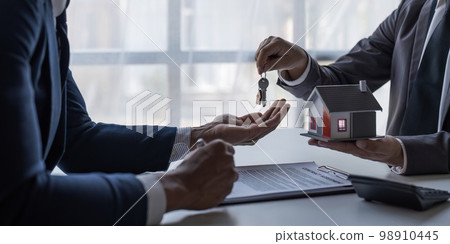 The house selling broker holds the keys and the model house is given to the customers,Real estate concept. 98910445