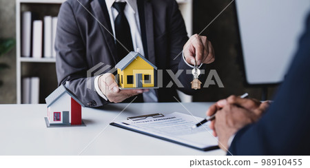 The house selling broker holds the keys and the model house is given to the customers,Real estate concept. The house selling broker holds the keys and the model house is given to the customers,Real estate concept. 98910455