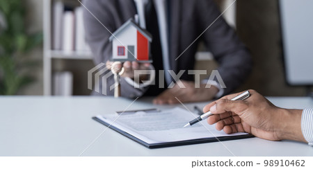 The house selling broker holds the keys and the model house is given to the customers,Real estate concept. 98910462