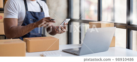 Starting small businesses SME owners man entrepreneurs Write the address on receipt box and check online orders to prepare to pack the boxes, sell to customers, sme business ideas online. 98910486