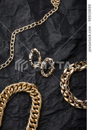 Golden chains earrings on black background. 98910699