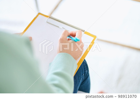 Part cut of a young woman holding a clipboard to answer a questionnaire 98911070