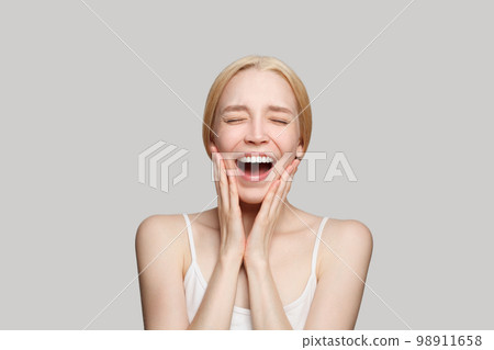 Portrait of happy surprised woman isolated on grey background. Beauty, cosmetics, skincare, glamour 98911658