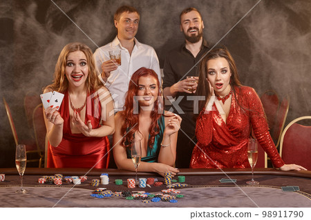 Group of a young wealthy friends are playing poker at a casino. 98911790