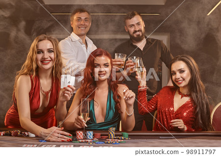 Group of a young wealthy friends are playing poker at a casino. 98911797