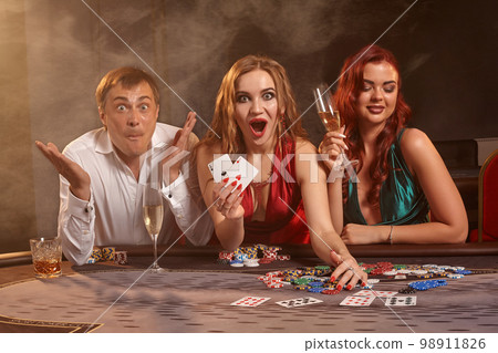Group of a young wealthy friends are playing poker at a casino. 98911826