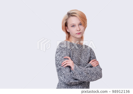 girl teenager in a closed position looks into the frame isolated on a light background girl teenager in a closed position looks into the frame isolated on a light background 98912136