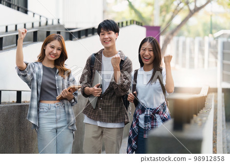 Beautiful young Asian woman college student with friends at outdoors. College student working on the college campus Beautiful young Asian woman college student with friends at outdoors. College student working on the college campus 98912858