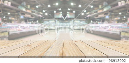Wood table top with supermarket grocery store blurred defocused background with bokeh light for product display 98912902