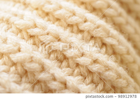 closeup beige knitted woolen fabric texture background closeup beige knitted woolen fabric texture background 98912978
