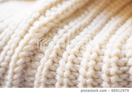 closeup beige knitted woolen fabric texture background closeup beige knitted woolen fabric texture background 98912979