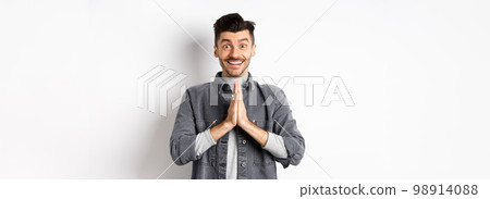 Please help me. Smiling cute man holding hands in namaste gesture, asking for favour, saying thank you, looking hopeful and excited at camera, standing on white background Please help me. Smiling cute man holding hands in namaste gesture, asking for favour, saying thank you, looking hopeful and excited at camera, standing on white background 98914088