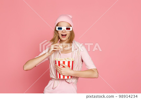 pretty blonde girl holding bucket of popcorn 98914234