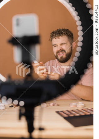 Bearded man professional beauty make up artist vlogger or blogger recording makeup tutorial to share on website or social media. Bearded man professional beauty make up artist vlogger or blogger recording makeup tutorial to share on website or social media. 98914413