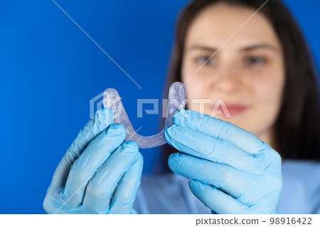 Doctor holding dental mouthguard, splint for the treatment of dysfunction of the temporomandibular joints, bruxism, malocclusion, to relax the muscles of the jaw. 98916422