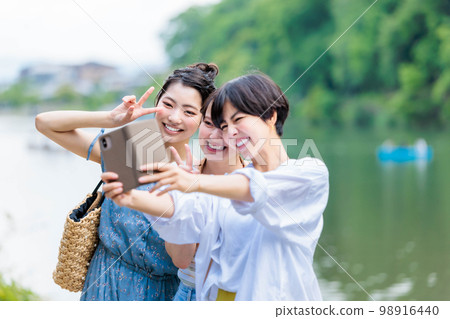 A woman taking a commemorative photo on a girls' trip 98916440