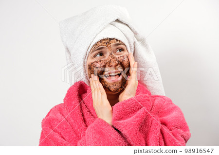 A woman with a mask on her face with her mouth open looks away, allergic to the composition of cosmetics for facial care A woman with a mask on her face with her mouth open looks away, allergic to the composition of cosmetics for facial care 98916547