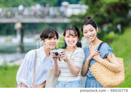 A young woman sightseeing with a camera on a girls' trip 98916778