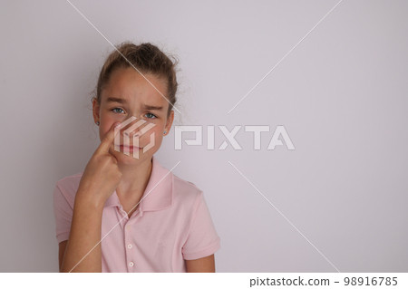 Little emotional teen girl in pink shirt 11, 12 years old on an isolated white background. Children's studio portrait. Place text, to copy space for inscription, advertising children's goods. Little emotional teen girl in pink shirt 11, 12 years old on an isolated white background. Children's studio portrait. Place text, to copy space for inscription, advertising children's goods. 98916785