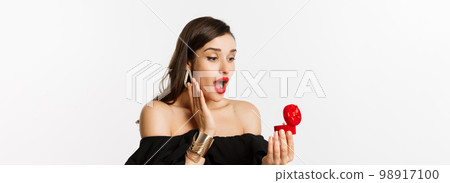 Close-up of surprised woman open box with engagement ring, looking amazed, receiving marriage proposal, girlfriend getting married 98917100